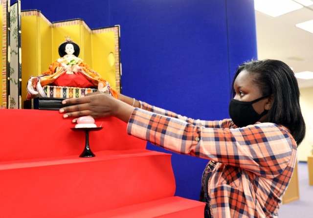 Madison Swanigan, 13, a member of Girl Scout Troop 600, places the empress doll on the “Hinamatsuri” display at the Camp Zama Library, Camp Zama, Japan, Feb. 18. The display’s top tier is reserved for the emperor and empress, and members of...