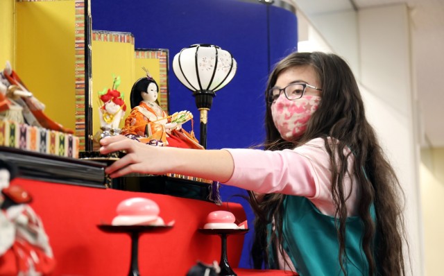Layla de Castro, 10, a member of Junior Girl Scout Troop 67, places a doll on the “Hinamatsuri” display at the Camp Zama Library, Camp Zama, Japan, Feb. 18.