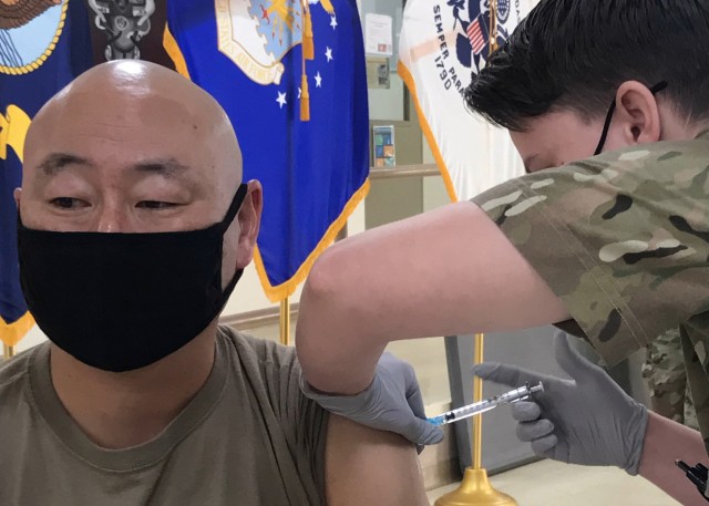 Lt. Col. Harold Yu, the deputy surgeon for Area Support Group-Kuwait and the officer-in-charge of the U.S. Army Health Clinic Kuwait, looks away as he receives his second Moderna COVID-19 vaccine dose Feb. 15, 2021 at the Camp Arifjan, Kuwait...