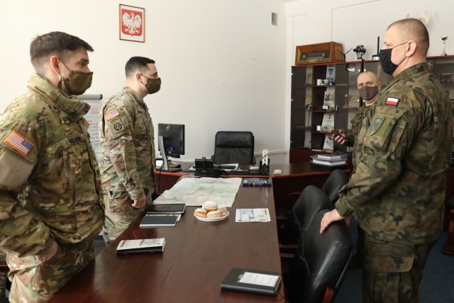 U.S. Army Captain Zack Shearin, left, and  Major Donald Huskey, adjacent, 1st Squadron, 2d Cavalry Regiment, enhanced Forward Presence Battle Group Poland, meet with Polish Army leaders from 1st Battalion, 15th Mechanized Brigade, February 11, 2021, in Orzysz, Poland to discuss cooperation on exciting upcoming joint-training exercises. (U.S. Army photo by Staff Sgt. Elizabeth O. Bryson)