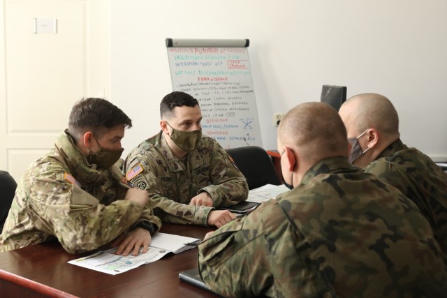 U.S. Army Captain Zack Shearin, left, and  Major Donald Huskey, adjacent, 1st Squadron, 2d Cavalry Regiment, enhanced Forward Presence Battle Group Poland, meet with Polish Army leaders from 1st Battalion, 15th Mechanized Brigade, February 11, 2021, in Orzysz, Poland to discuss cooperation on exciting upcoming joint-training exercises. (U.S. Army photo by Staff Sgt. Elizabeth O. Bryson)