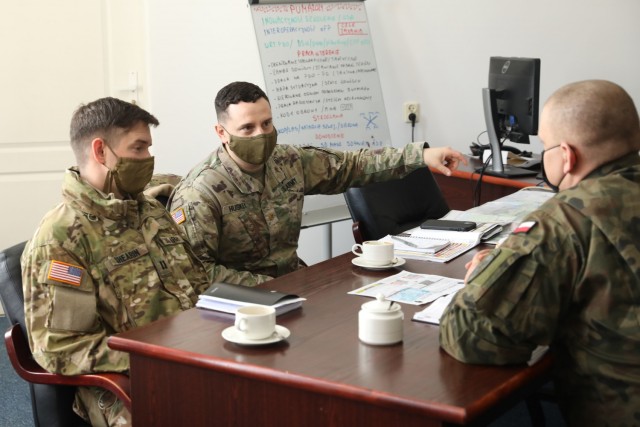 U.S. Army Captain Zack Shearin, left, and  Major Donald Huskey, adjacent, 1st Squadron, 2d Cavalry Regiment, enhanced Forward Presence Battle Group Poland, meet with Polish Army leaders from 1st Battalion, 15th Mechanized Brigade, February 11, 2021, in Orzysz, Poland to discuss cooperation on exciting upcoming joint-training exercises.(U.S. Army photo by Staff Sgt. Elizabeth O. Bryson)