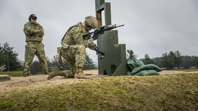 Staff Sgt. Shamus McNamara, assigned to 2nd Cavalry Regiment, reloads his M4 carbine in front of Staff Sgt. Jeffrey Cline, a Marksmanship Master Trainer course instructor, during the MMT course, Grafenwoehr Training Area, Germany, Feb. 3, 2021....