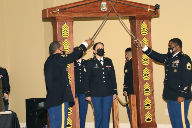 Sgt. Gladys Lugo, a medical laboratory technician with Weed Army Community Hospital, prepares to cross the threshold into the noncommissioned officer corps during an NCO Induction Ceremony February 11 at the Sandy Basin Community Center on Fort Irwin, Calif. Lugo, a Los Angeles native, and 16 other NCOs participated in the ceremony welcoming them into the NCO corps. (U.S. Army photo by Kimberly Hackbarth/ Weed ACH Public Affairs)
