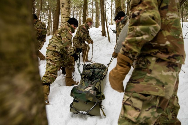 Soldiers from Headquarters and Headquarters Company, 1st Battalion, 87th Infantry Regiment, 1st Brigade Combat Team, 10th Mountain Division (LI), pull a litter with a simulated casualty through snowy terrain at Camp Ethan Allen Training Site, in Jericho, Vt., Feb. 19, 2021. The Soldiers received the training as a reward for placing as one of the top three teams to complete the D-Series challenge held at Fort Drum, N.Y. Feb. 9-10. (U.S. Army photo by Sgt. Elizabeth Rundell, 27th Public Affairs Detachment)
