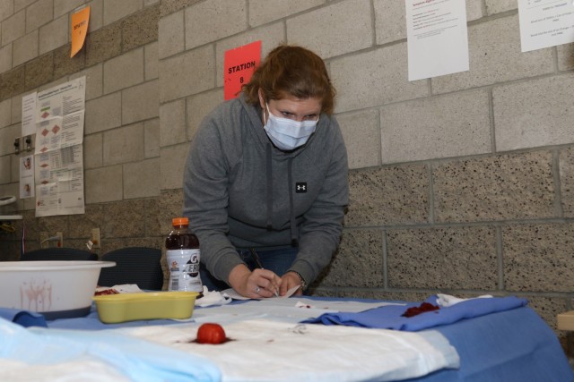 Capt. Kathryn Fekete, a pediatrician with Weed Army Community Hospital, estimates how much artificial blood is present at the estimating blood loss station during the Weed ACH skills fair January 21 at the Mary E. Walker Center at Fort Irwin,...