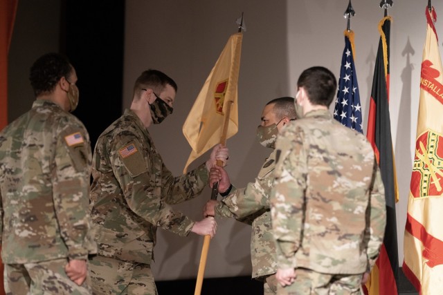 WIESBADEN, Germany -- Capt. Alexander Moore, incoming commander of Headquarters and Headquarters Company, completes the passing of the colors at the live streamed change of command ceremony Feb. 19 at U.S. Army Garrison Wiesbaden.