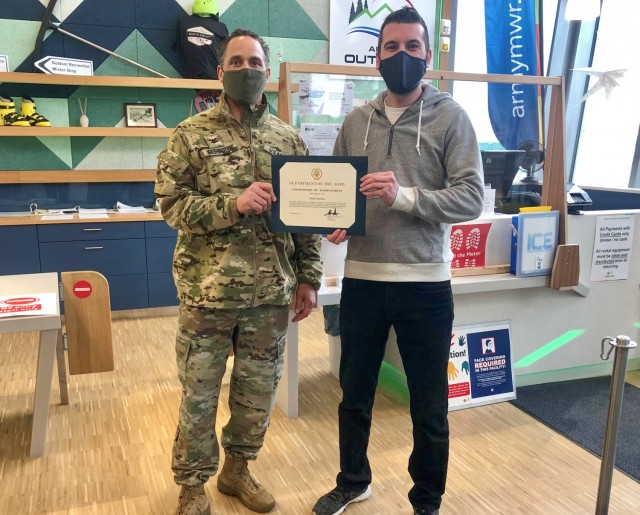 Garrison Commander Col. Mario Washington, issues the $500 award and certificate of recognition to Sedat Selmani, recreation assistant, Feb. 19, 2021.