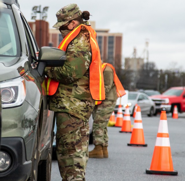 U.S. Air Force Staff Sgt. Paula Helms, a religious affairs sergeant with the Savannah-based 165th Airlift Wing, greets patrons in line to receive a COVID-19 vaccine, Feb. 22, 2021, at the Delta Flight Museum in Hapeville, Georgia. The Georgia...