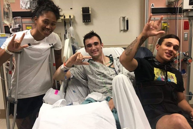 Army Sgt. Aechere Crump, left, and Army Pfc. Victor Alamo, right, visits with Army Spc. Ezra Maes during their recovery at Brooke Army Medical Center, Joint Base San Antonio-Fort Sam Houston, Texas. Crump and Alamo survived a tank accident with...