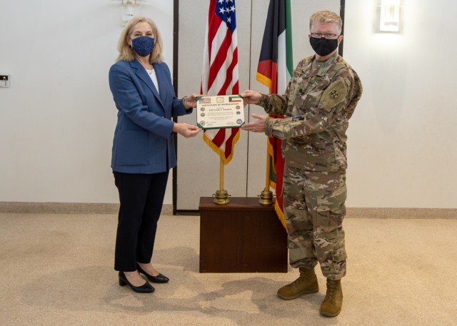 Ambassador Alina L. Romanowski, United States ambassador to Kuwait, presents a certificate of appreciation to Lt. Col. Frank J. Vazzana, command surgeon, 310th Expeditionary Sustainment Command, for his efforts in providing life-saving measures and assisting a local victim of a catastrophic vehicle accident in Kuwait City, Kuwait, Feb. 18, 2021. (U.S. Army Photo by Spc. Zoran Raduka, 1st TSC Public Affairs)