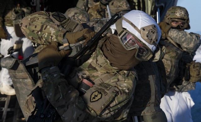 A U.S. Army paratrooper, assigned to 4th Infantry Brigade Combat Team (Airborne), 25th Infantry Division (Spartan Brigade), adjusts his ruck sack as he exit’s a C-130J Super Hercules, assigned to the 36th Airlift Squadron, Yokota Air Base, Japan, as part of exercise Arctic Warrior 21 at Donnelly Training Area, AK, Feb. 8, 2021. The exercise demonstrated the capability of U.S. military forces in the pacific and arctic region to operate in austere winter conditions to face near-peer threats, bolstering safety and stability in the region. (U.S. Air Force photo by Staff Sgt. Gabrielle Spalding)