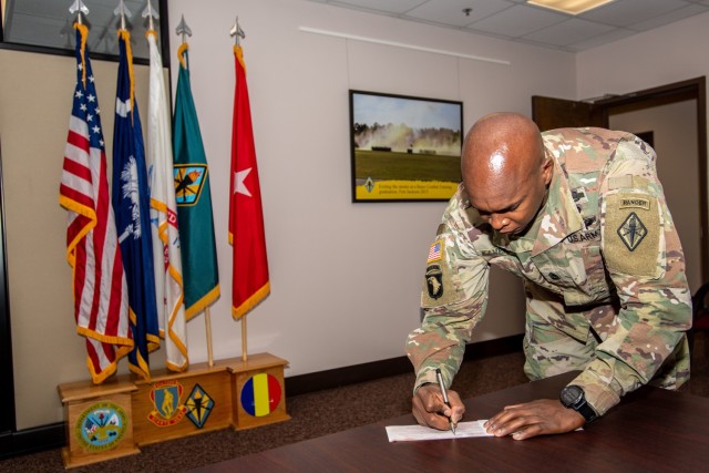 Post Command Sgt. Maj. Philson Tavernier signs his pledge for the kickoff of the Army Emergency Relief campiagn, Feb. 17.