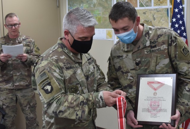 While MAJ John Zook overlooks the presentation script, Sergeant Major Nathan Marshall and Lieutenant Colonel Paul Sipe admire the de Fleury medal. (Photo by Rick Benoit)