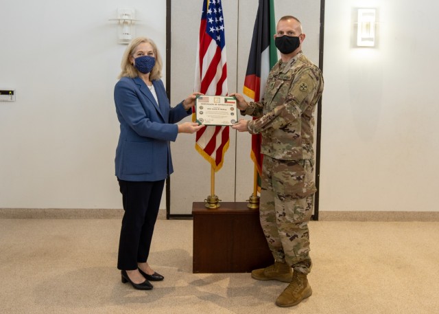 Ambassador Alina L. Romanowski, United States ambassador to Kuwait, presents a certificate of appreciation to Staff Sgt. Justin Roadknight McKay, senior medic, 310th Expeditionary Sustainment Command, for his efforts in providing life-saving measures and assisting a local victim of a catastrophic vehicle accident in Kuwait City, Kuwait, Feb. 18, 2021. (U.S. Army Photo by Spc. Zoran Raduka, 1st TSC Public Affairs)