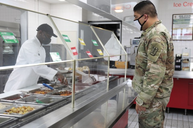 Staff Sgt. Ricardo Morales, right, assigned to the 311th Military Intelligence Battalion, orders lunch Jan. 26 at the dining facility at Camp Zama, Japan. Serving him is a member of the 35th Combat Sustainment Support Battalion’s field feeding platoon. When services at the dining facility were interrupted Jan. 21, the field feeding platoon took over operations and began providing hot, takeout-only meals to customers three times a day, seven days a week.