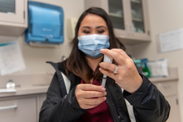 Bebita Caasi, a nurse with the California Medical Detachment pulls a shot of the COVID-19 vaccine this February.