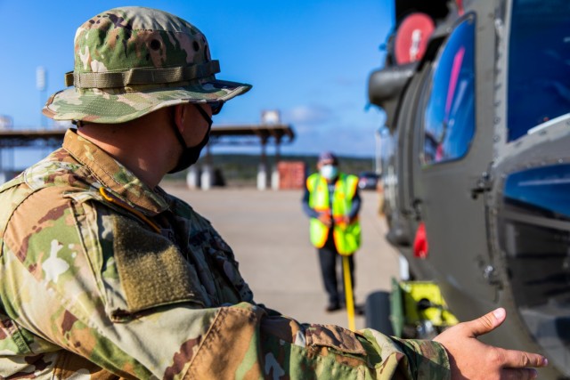 Spc. Mika Garcia, a UH-60 Helicopter Repairer from 3rd Battalion, 227th Aviation Regiment, 1st Air Cavalry Brigade, 1st Cavalry Division, helps Cruz Baca, a Transportation Assistant, in finding the center of balance for the UH-60 Black Hawk at...