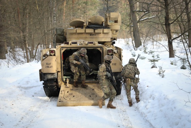 Dismount infantrymen assigned to 2nd Battalion, 8th Cavalry Regiment, race out of the back of a Bradley Fighting Vehicle Feb. 21, 2021, as they participate with Lithuanian 21st Dragoon Battalion in a combined training exercise. The Troopers traveled a two-mile route where they were faced with small units of Lithuanian forces who placed various ambushes along the route. The training event tested the abilities of U.S. forces to identify and react to ambushes and the Dragoon Battalion to slow or halt the advance of heavy weaponry. (U.S. Army photo by Sgt. Alexandra Shea)
