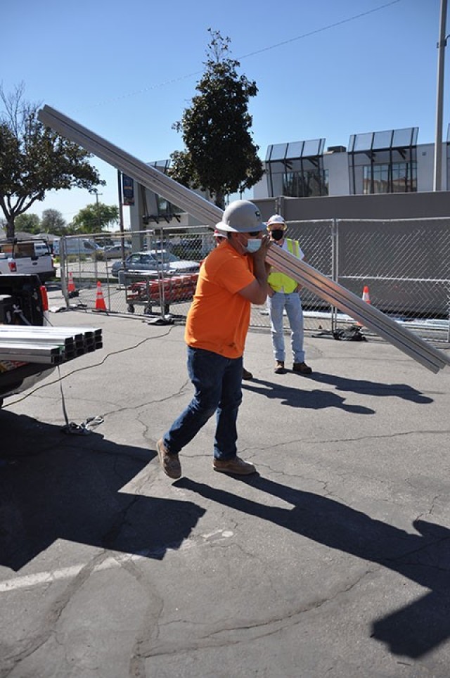 A construction worker moves construction materials to the roof of Beverly Hospital, Montebello, California, Feb. 23, 2021.