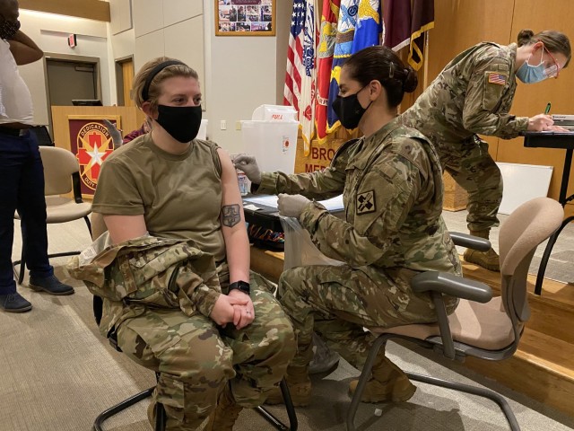 Dr. Nadia Pearson, U.S. Army Medical Center of Excellence Command Surgeon administers the COVID-19 vaccine on February 1, 2021 at Brooke Army Medical Center (BAMC) on Joint Base San Antonio-Fort Sam Houston, Texas to Senior Airman Baylie Higgins, a medical technician who works on BAMC’s COVID-19 ward.