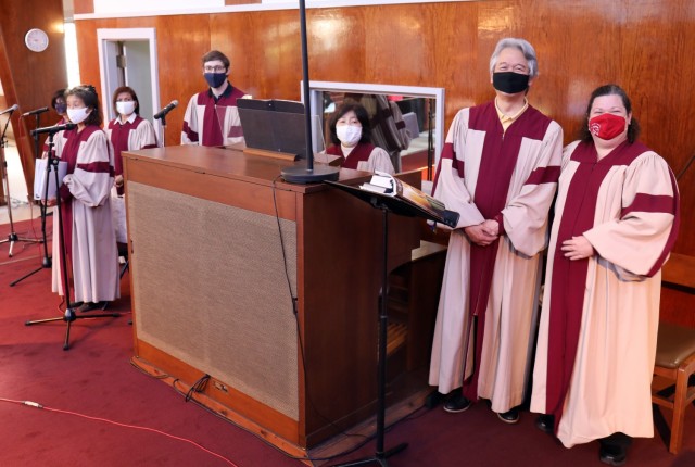 Shunji Sakita, second from right, director of the choir for the Holy Family Catholic Community, poses for a photo with members of the choir before Mass at the Camp Zama Chapel, Camp Zama, Japan, Feb. 21. Sakita’s wife Takako Sakita, a concert...