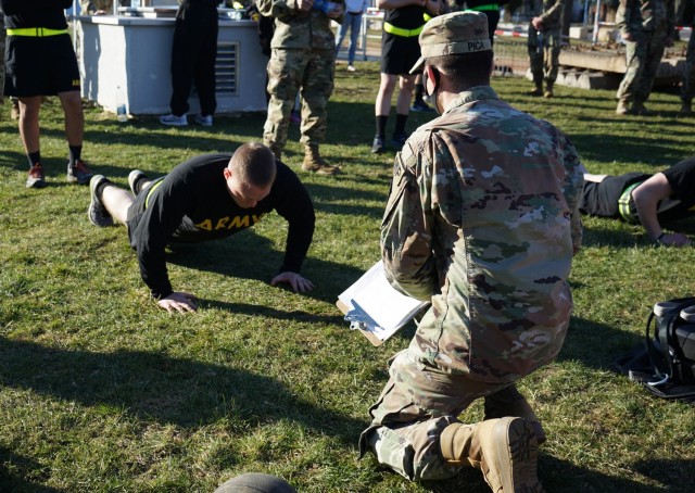 Sgt. Sebastiano Pica, USAG Ansbach, grades a Soldier's push ups during the Army Combat Fitness Test Feb. 28 at Katterbach Fitness Center as part of the Installation Management Command-Europe Best Warrior Competition running from Feb. 28 to Mar. 3.  The competition enhances expertise, training, and understanding of the skills needed to be a well-rounded Soldier. Winners will go on to compete at the Installation Management Command level in San Antonio, Texas.