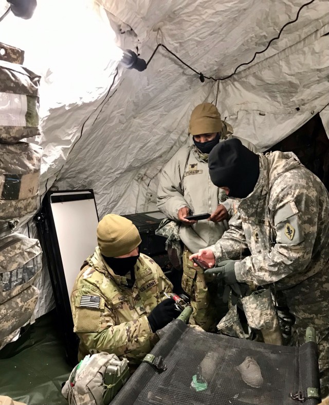 (L-R): A medic from 4th Brigade, 25th Infantry Division, Lt. Col. Cleve Sylvester, and Master Sgt. David Edwards, assess CLVIII at Role 1, in support of Arctic Warrior 2021 at Fort Greely, Alaska, February 6-12, 2021.