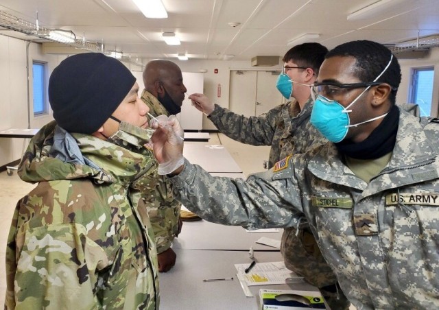 Col. Joselito Lim (left) and Lt. Col. Cleve Sylvester (middle), are screened by medics from 1/25 ID as part of daily COVID-19 screening prior to start of Arctic Warrior in Fort Greely, Alaska, February 6-12, 2021.  