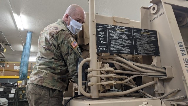 HAYS, Kan. – Sgt. 1st Class Lyndon Ellis, Field Maintenance Shop 1 mechanic, conducts routine preventive maintenance checks and services Jan. 28, 2021. FMS 1 took first place at the National Guard Bureau for the annual Army Award for Maintenance...