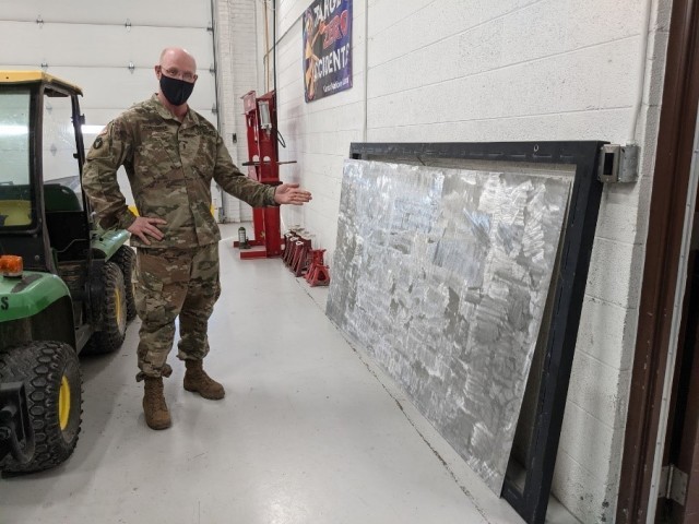 HAYS, Kan. – Chief Warrant Officer 3 Michael Schmidtberger, Field Maintenance Shop 1 shop foreman, shows off a work in progress for their outdoor shop sign Jan. 28, 2021. Part of their new sign is being finished in Salina as the former one...