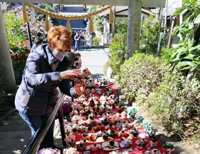 Suzanne Ohsiek, participating in a U.S. Army Garrison Japan Army Community Service walking tour, takes photos of “Hinamatsuri” dolls at the Zama Shrine, Zama, Japan, March 3.