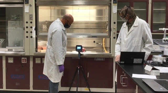 Electrical engineer Dr. Phillip Wilcox and research chemist Dr. Jason Guicheteau test the capabilities of a handheld standoff chemical detection device in a DEVCOM CBC laboratory.