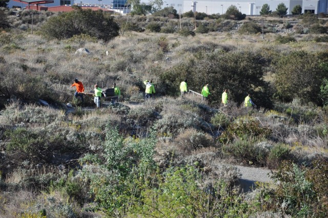 Contractors hired by the U.S. Army Corps of Engineers Los Angeles District file in and out of the San Gabriel River riverbed, March 1, 2021.