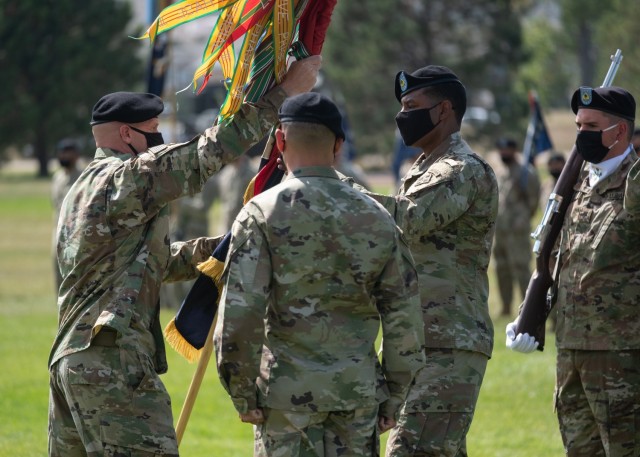 Command Sgt. Maj. Jerry Higley, left, brigade Command Sgt. Maj., 1st Stryker Brigade Combat Team, 4th Infantry Division, passes the brigade colors to Sgt. Maj. Willie Woods, the change of responsibility ceremony commander of troops at Fort Carson, Colorado, September 23, 2020. The passing of the colors symbolizes the passing of responsibility from one leader to another. (U.S. Army photo by Capt. Daniel Parker)