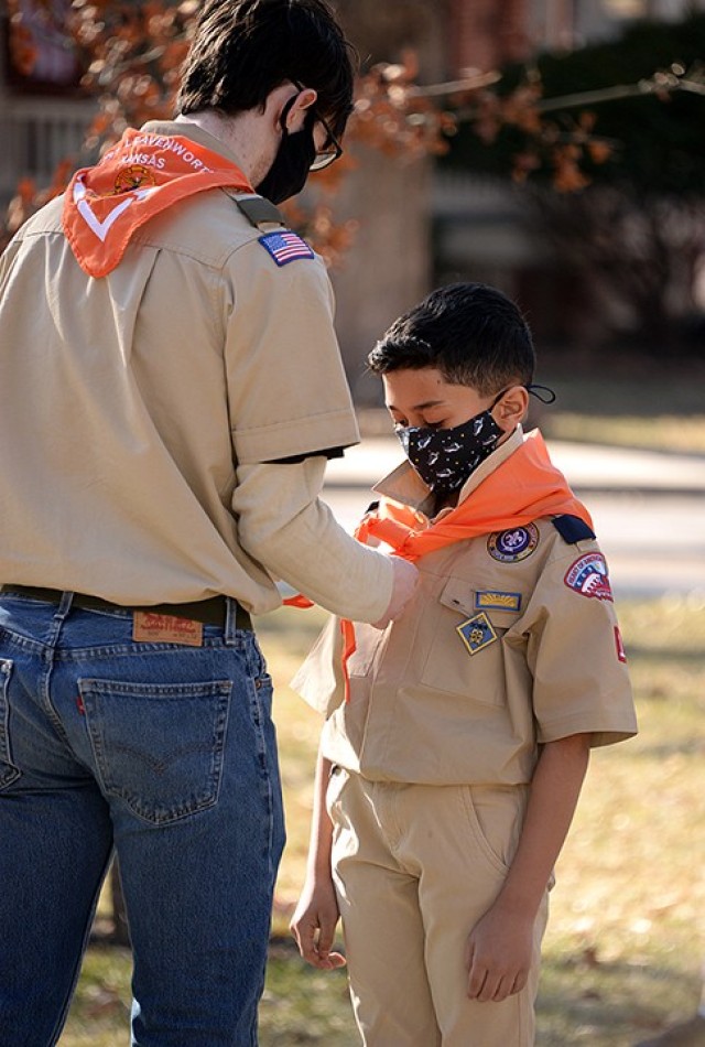 Senior Patrol Leader Ethan Herken replaces 10-year-old Jayden Palmer's Webelos neckerchief with Troop 366's bright orange neckerchief during the Cub Scouts to Scouts BSA crossover ceremony Feb. 27 at Zais Park. Photo by Prudence Siebert/Fort...