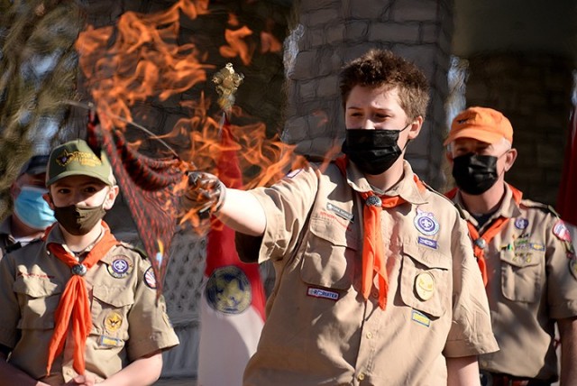 Thirteen-year-old Scout Sam Rowley, Troop 366 fire support, lights a Webelos neckerchief on fire, using a solution that would only make it appear to be on fire but not actually burn it, while observed by 12-year-old Scout Ben Sweet, also Troop 366...