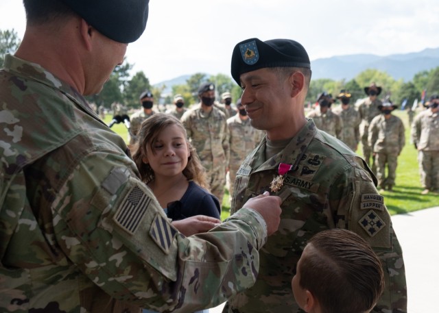 Col. Ike Sallee, commander, 1st Stryker Brigade Combat Team, 4th Infantry Division, pins the Legion of Merit on Command Sgt. Maj. Delfin Romani's collar at the 1st SBCT, 4th Inf. Div. change of responsibility ceremony at Fort Carson, Colorado, September 23, 2020. Romani was awarded the LOM in recognition of his service during his tenure as the 1st SBCT Command Sgt. Maj. (U.S. Army photo by Capt. Daniel Parker)