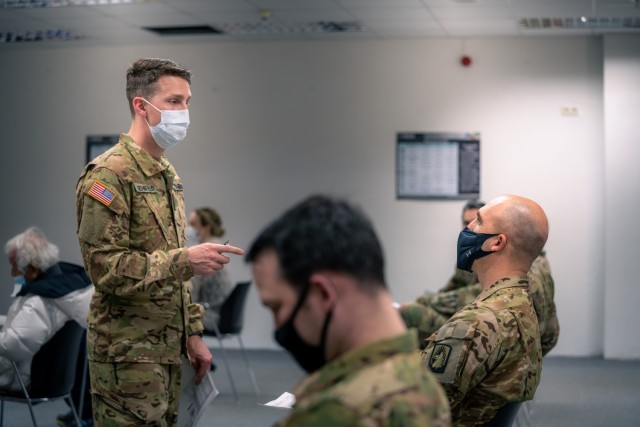U.S. Army Capt. (Dr.) Charles Behnfield, flight surgeon for the 1st Battalion, 214th Aviation Regiment, 12th Combat Aviation Brigade, goes over questions and instructions with Soldiers prior to receiving their second COVID vaccine on Feb. 24,...