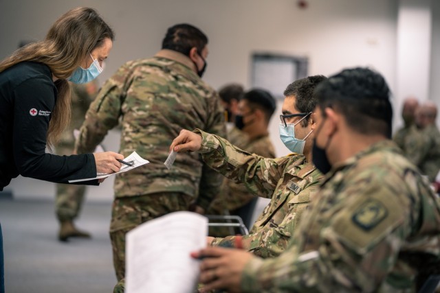 A U.S. Army Soldiers from 1st Battalion, 214th Aviation Regiment, 12th Combat Aviation Brigade, go through questions and instructions prior to receiving their second COVID vaccine on Feb. 24, 2021, in Wiesbaden, Germany. (U.S. Army photo by Maj....