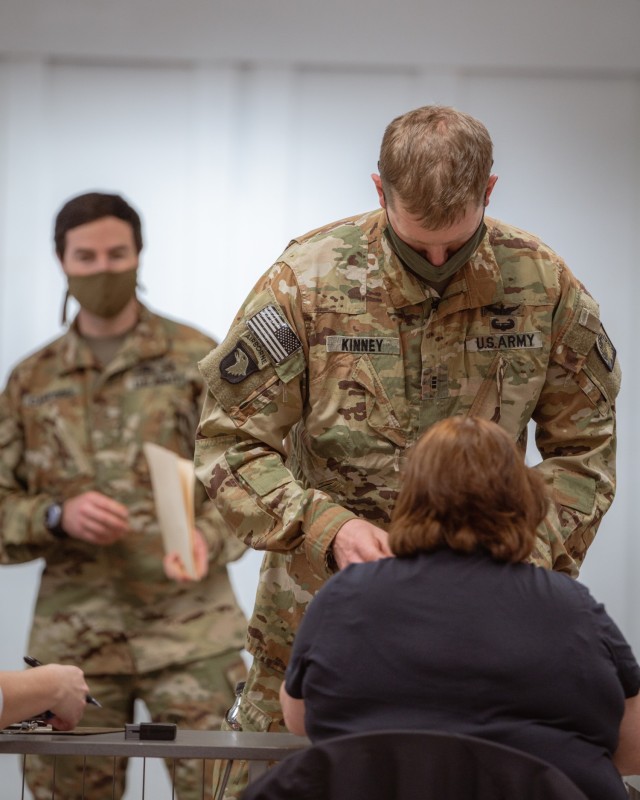 Chief Warrant Officer 3 Kinney, a UH-60 pilot from 1st Battalion, 214th Aviation Regiment, 12th Combat Aviation Brigade, verifies his identity and shot record before receiving the second and final COVID vaccine dose on Feb. 24, 2021, in Wiesbaden,...