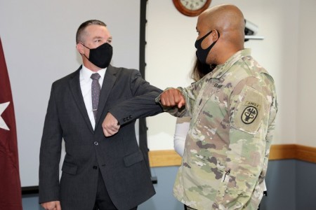 Robert Winchel, left, a managed care analyst at Madigan Army Medical Center, Joint Base Lewis-McChord, Wash., receives a congratulatory elbow bump Oct. 1, 2020. Winchel was selected as the U.S. Army Medical Command's civilian of the year. The Army recently posted its highest overall scores on the Federal Employee Viewpoint Survey. The survey measures employees' perception of what makes a successful organization and whether their agencies and employers have those characteristics. 
