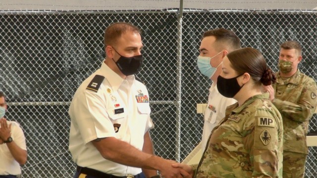 Capt. Anthony Gardull, Commander, 483rd Military Working Dog, and 18th Military Police Detachments presents challenge coins to Soldiers during a Buffalo Soldier Day’s event at Fort Huachuca, Ariz.