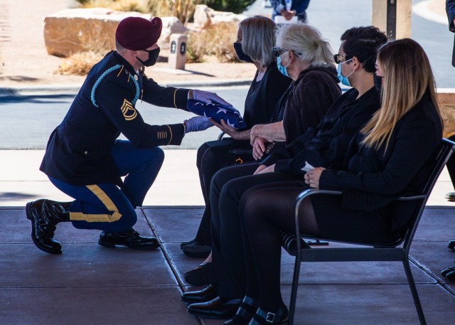 Sgt. 1st Class Micheal Stroud, a platoon sergeant assigned to D Company, 2nd Battalion, 325th Airborne Infantry Regiment, 2nd Brigade Combat Team, 82nd Airborne Division, presents the U.S. Flag to Marlene Ritts, the daughter of recently deceased...
