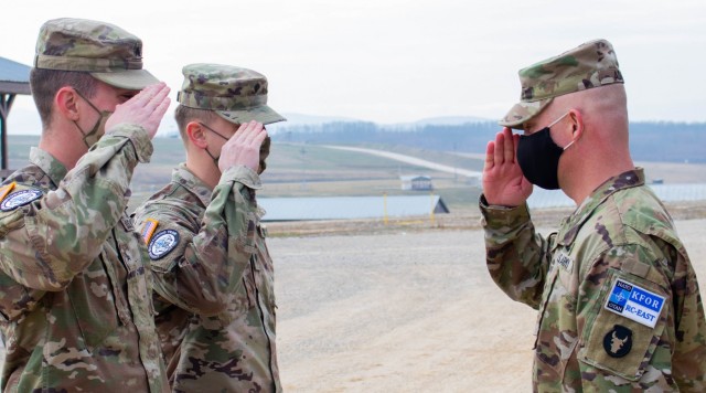 Sgt. Spenser Sharp and Spc. Cole Magnuson salute Col. Derek Adams, commander of Regional Command-East, Kosovo Force, during a recognition presentation at Camp Bondsteel, Kosovo, on March 8, 2021. Adams presented Sharp and Magnuson, of Sioux City, Iowa, with Ryder Brigade coins to award them for stopping to aid civilians on their way back from a routine mission. (U.S. Army National Guard photo by Sgt. Jonathan Perdelwitz)