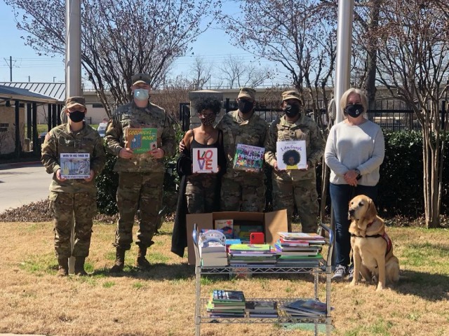 A group of Soldiers from Bravo Company, 303rd Military Intelligence Battalion, 504th Military Intelligence Brigade, along with Jasmine Kirk and her brother Sgt. Joshua Kirk, pose for a photo at the Ronald McDonald House, Dallas, Texas, March 5, 2021. The group took a portion of the donated books to the house to be given to the children. (U.S. Army courtesy photo)