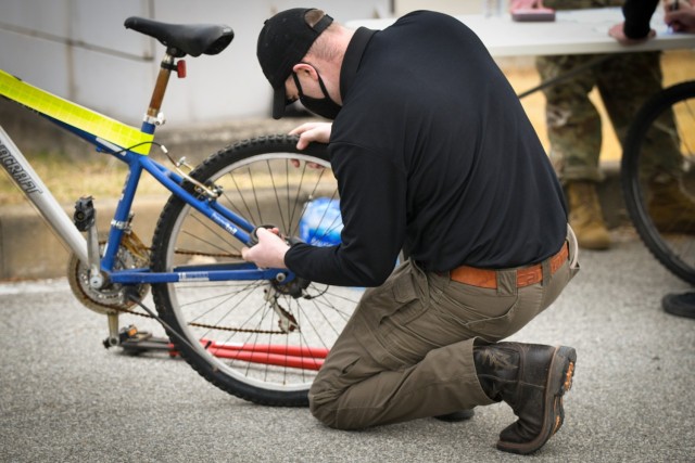 CAMP HUMPHREYS, Republic of Korea - Staff Sgt. Michael Wait, the operations Noncommissioned Officer in Charge for the USAG Humphreys Provost Marshall Office, removes a lock from a previously impounded bike given out during the 2nd Annual Area III USAG Humphreys Religious Support Office (RSO) Community Bicycle Giveaway here, March 6.  During the event, approximately 100 bicycles were which had been previously abandoned or impounded were given out to community members, helping to ensure their effective mobility and transportation. (U.S. Army photo by Spc. Matthew Marcellus)