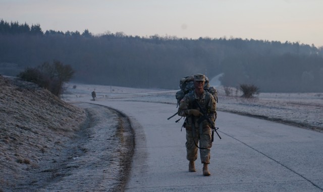 Pfc. Samuil Matveev, USAG Rheinland Pfalz, passes the halfway point during the 10.6 mile ruck march at Oberdachstetten Training Area March 3 as the final event of the Installation Management Command-Europe Best Warrior Competition running from Feb. 28 to Mar. 3. The competition enhances expertise, training, and understanding of the skills needed to be a well-rounded Soldier. Winners will go on to compete at the Installation Management Command level in San Antonio, Texas.