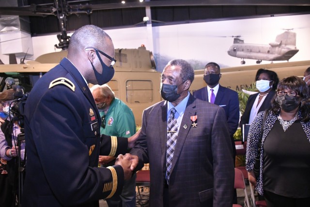 Brig. Gen. James Smith, Chief of Transporation, congratulates former Army Spc. Ronald Mallory after presenting him with the Bronze Star Medal with &#34;V&#34; device following a ceremony March 4 at the Army Transportation Museum.