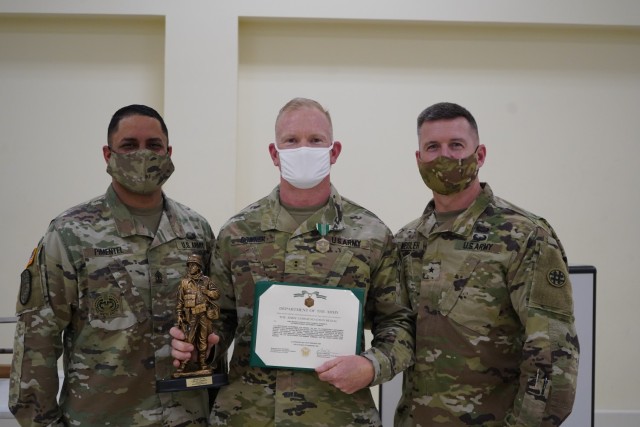 Chief Warrant Officer Two Thomas Downer [Center] receives and Army Commendation Medal from Brig. General Kevin F. Meisler [Right], the commanding general of  the 4th Sustainment Command (Expeditionary), and 1st Sgt. Jorge Pimentel [Left], 4th ESC Headquarter Company First Sergeant.